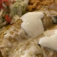 Two Enchiladas · Two tortillas with meat and melted cheese, mole sauce, and sour cream on top. Served with sa...