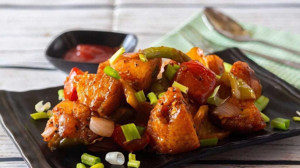 Chili Idli · Steamed rice cake cubes tossed in chili sauce topped with bell peppers, onions, spring onions, and cilantro.