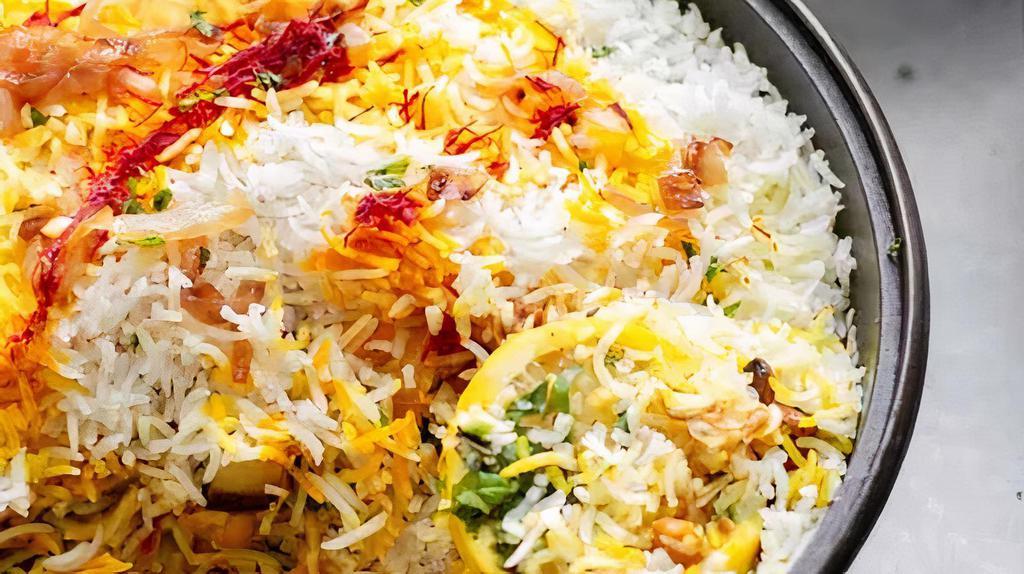 Shrimp Dum Biryani · Authentic 'Dum' biryani is an aromatic, mouth watering and authentic dish with succulent jumbo shrimp in layers of basmati rice, fragrant spices and caramelized onions served with raita and salan