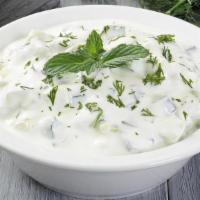 Yogurt Cucumber Dip · Yogurt mixed with dried mint and pepper, topped with diced cucumber.