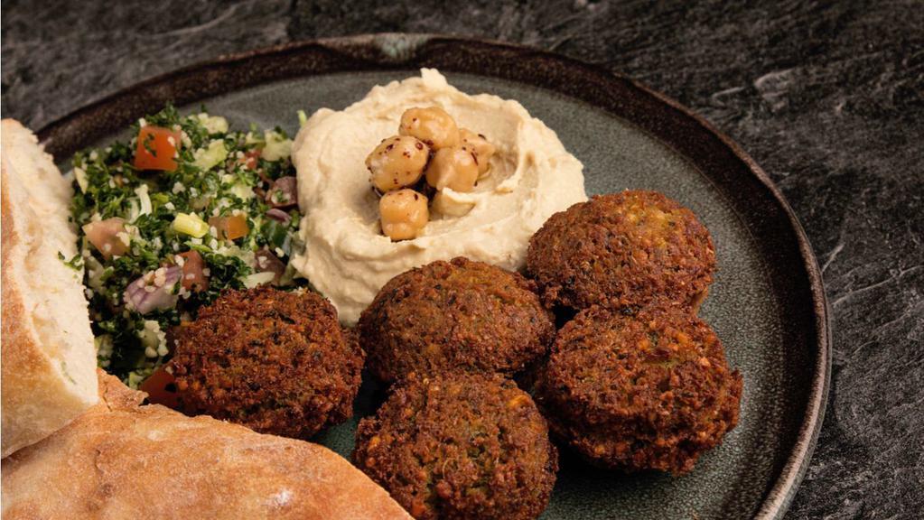 Falafel Plate · Mix of golden Garbanzo beans with garlic, beans and Garbanzo with garlic, onions, herbs and spices. Served with salad, hummus, tahini sauce and pita bread.