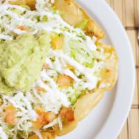 Tostada Suprema · A crispy flour shell covered with beans, meat topped with shredded lettuce, cheese, sliced t...