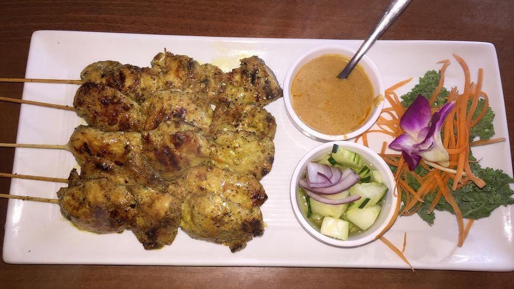 Chicken Satays · Chicken skewers marinated in herbs, spices, yellow curry powder. Served with peanut sauce and cucumber salad.
