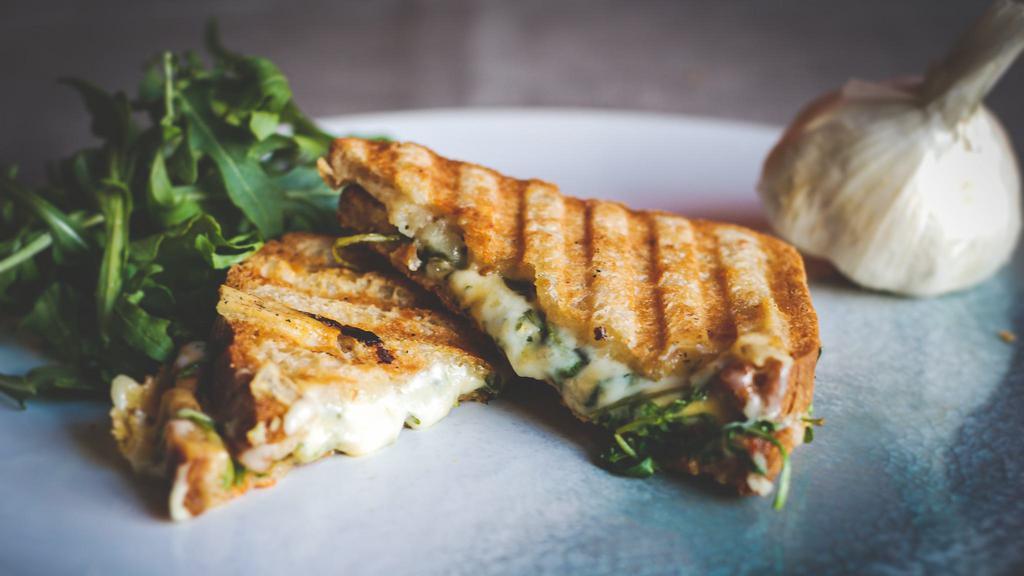 Garlic Grilled Cheese · Gluten-free bread, garlic ghee, arugula, organic cheddar cheese, and organic pepper jack cheese. Served with green sauce on the side.