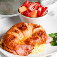 Croissant Breakfast Sandwich · Ham or Turkey, scrambled eggs, and cheese layered on a grilled croissant. Served with fruit ...