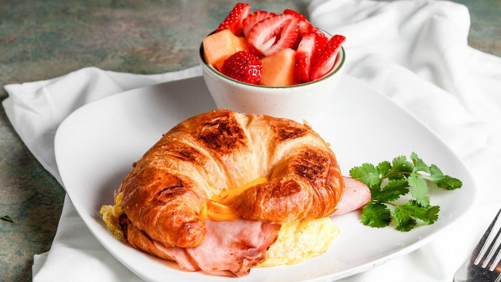 Croissant Breakfast Sandwich · Ham or Turkey, scrambled eggs, and cheese layered on a grilled croissant. Served with fruit or potatoes. 650-1198 cal.