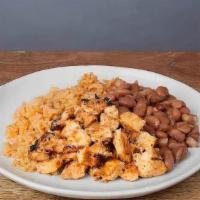 KID CHICKEN * · A small plate of pollo asado with rice and pinto beans