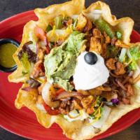 Fajitas Tostada Salad · Tortilla shell filled with warm black beans, lettuce, tomatoes, grilled chicken breast, chee...