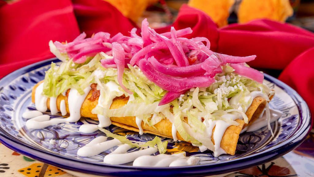 Flautas · Cochinita pibil, red onions with habanero, lettuce, sour cream, and cheese.
