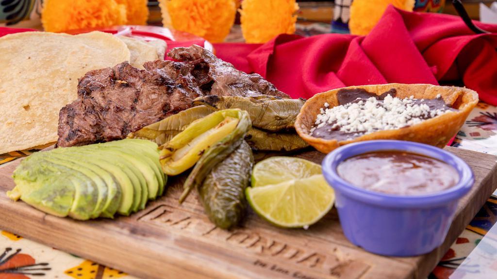 Arrachera · Squirt steak, cactus, chorizo, refried beans, cambray onions, roasted jalapeño, and handmade tortillas.