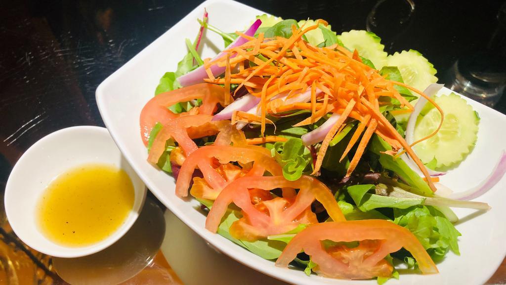 SA8. Green Salad · Our house salad with lettuce, cucumbers, carrots, tomatoes, onions, served with lime dressing.