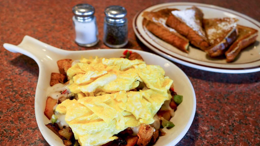 Country Skillet · Diced country fried steak, sautéed peppers and onions over seasoned homestyle potatoes, topped with country sausage gravy and two eggs.