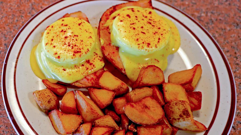 Eggs Benedict · Two eggs and two slices of ham over a halved and grilled English muffin, topped with a delicious Hollandaise sauce. Served with seasoned home fries. Does not include toast.