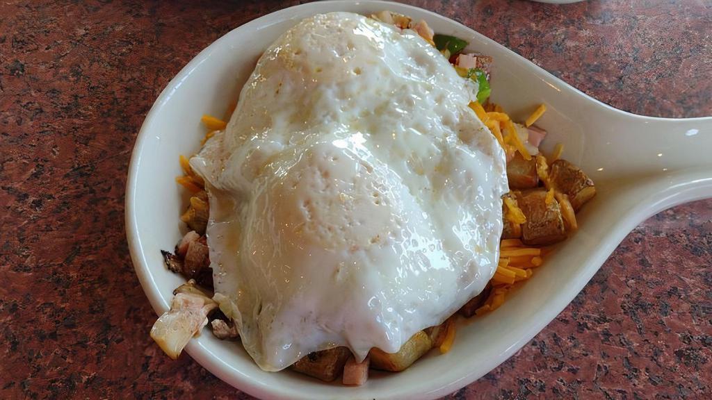 Farmer's Skillet · A sautéed blend of diced ham, peppers, mushrooms, and onions over seasoned homestyle potatoes, topped with melted cheddar cheese and two eggs.
