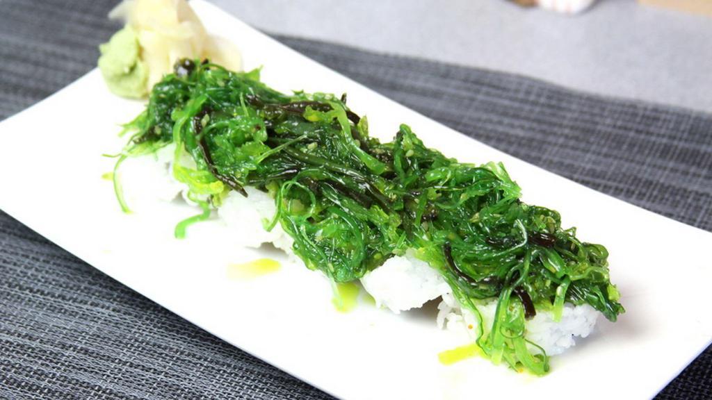 Green Island Roll · Salmon, tuna, hamachi, avocado, cucumber topped with seaweed salad.