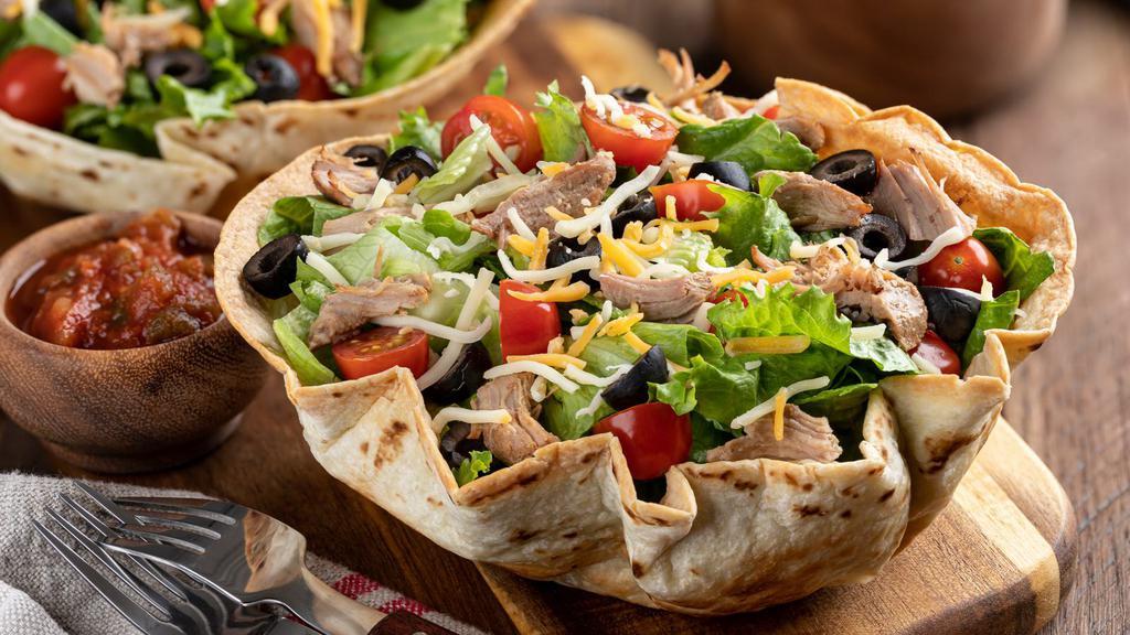 Carnitas Taco Salad · Delicious carnitas salad featuring romaine, rice, beans, fresh salsa, guacamole, cheeses and sour cream. Served with a crisp tortilla shell.