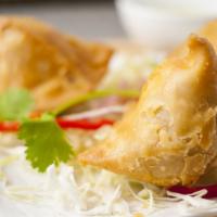 Samosa · Vegetable masala stuffed in a flaky pastry shell and deep fried.