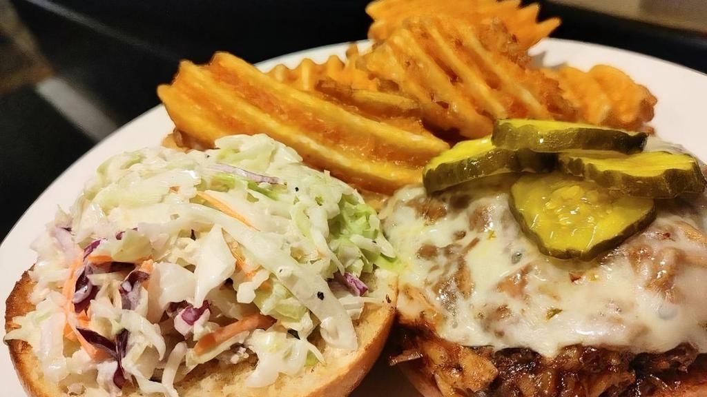 Pulled Pork Sandwich · apple cider slaw, pepper jack cheese, waffle fries, brioche bun, bread and butter pickles
