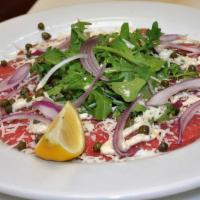 Beef Carpaccio · Thinly sliced  raw filet mignon, topped with capers, red onions, arugula, Parmigiano-Reggian...
