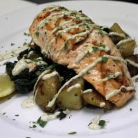 Grilled Salmon · Served over Yukon gold potato hash, sautéed spinach and topped with lemon caper aioli.