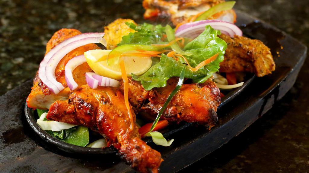 Chicken Tandoori · Chicken on the bone marinated in yogurt, ginger and freshly ground spices. Skewered and grilled to perfection and served in a sizzling platter.