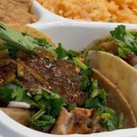 Taco Plate · Two taco's with choice of meat, onions, cilantro, hot salsa, served with choice of beans and...