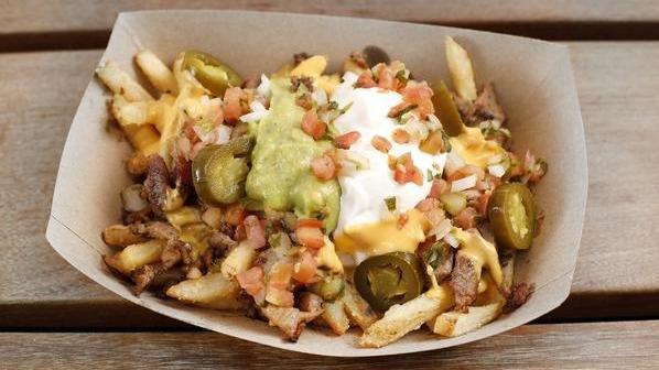 Sisig Fries · French fries topped with nacho cheese, sour cream, guacamole, pico de gallo and pickled jalapeños.