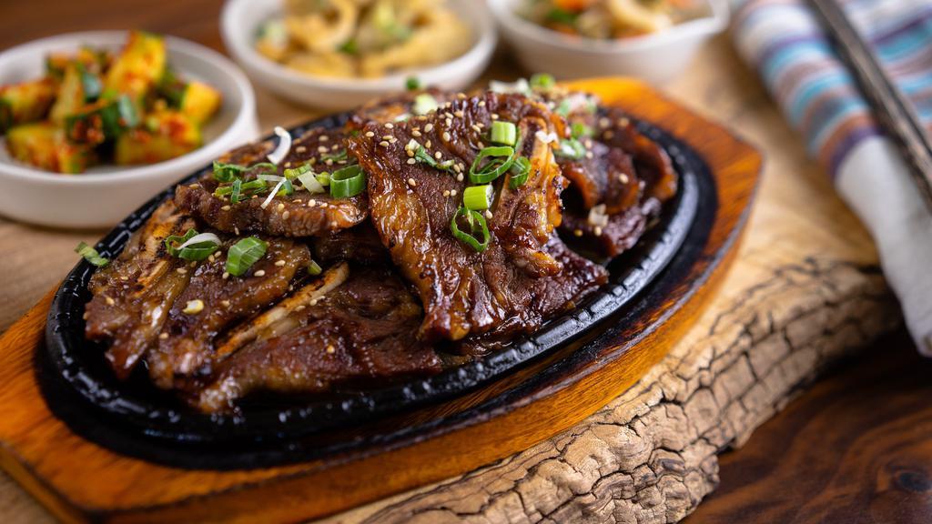 Beef Short Ribs · Beef short ribs served with rice and an assortment of kimchi dishes.
