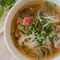 11. Combo Phở (L) · Beef Pho topped with brisket, rare steak, flank, tendon, tripe, and meatballs.
