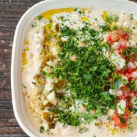 Masabacha · Hummus mixed with warm spiced organic garbanzo beans, tahini, tomatoes, onions, pickles, and...