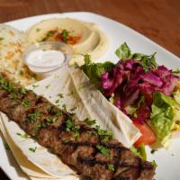 Adana  Kebab Plate · Ground lamb and beef skewer with parsley, red onion. Served with rice, salad, hummus and pita.