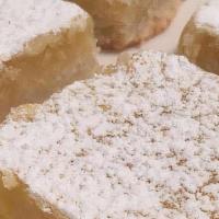 Lemon Bar · A beloved classic treat! Buttery shortbread crust, tangy lemon filling, and a dusting of pow...