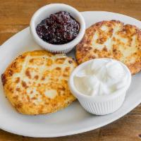 Syrniki · Sweet cheese fritters, served with sour cream