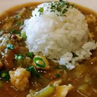 Gumbo with Rice (Chicken & Sausage) · A strongly flavored stew served with a scoop of rice.