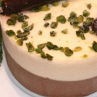 Duo Chocolate Mousse · Silky layers of dark and white chocolate mousse on a sponge base, topped with a morello cher...