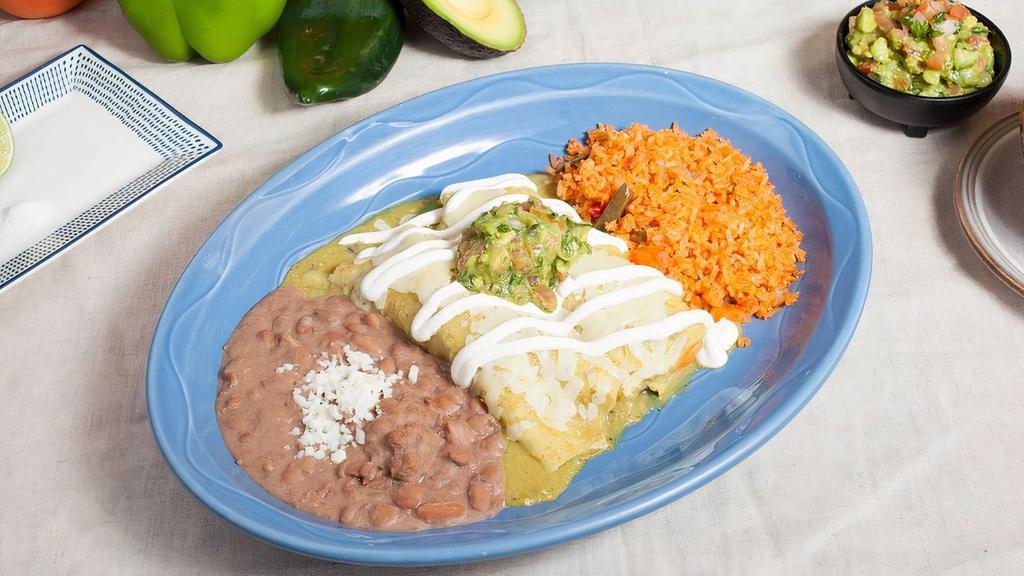 Enchiladas Suizas · Two corn tortillas with shredded chicken. Topped with our spicy green tomatillo sauce, cheese, crema, and guacamole. Served with rice and beans.