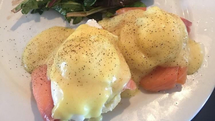 Smoke Salmon Benedict · Poached eggs on a homemade buttermilk biscuit with smoked salmon, chives, avocado, hollandaise sauce & mixed greens.
