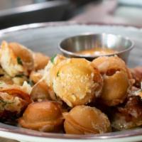 Pelmeni · Siberian dumplings sauteed in garlic, butter and parmesan. Side of sour cream. Your choice o...