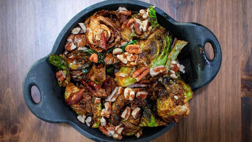 Brussel Sprouts · Crispy fried Brussel Sprouts tossed in Maple syrup, sherry vinaigrette and topped with bacon and crushed pecans (v)