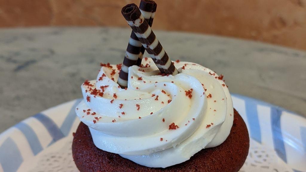 Red Velvet Cupcake · Our delicious and moist chocolate cake is topped with a cream cheese frosting and a chocolate batons.