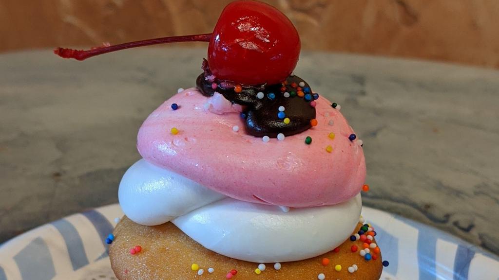 Sundae Cupcake · Our delicious sundae cupcake is a moist vanilla cupcake with strawberry and vanilla buttercream topped with sprinkles and a cherry!