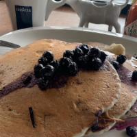 blueberry Pancakes · Three blueberry pancakes with blueberry sauce