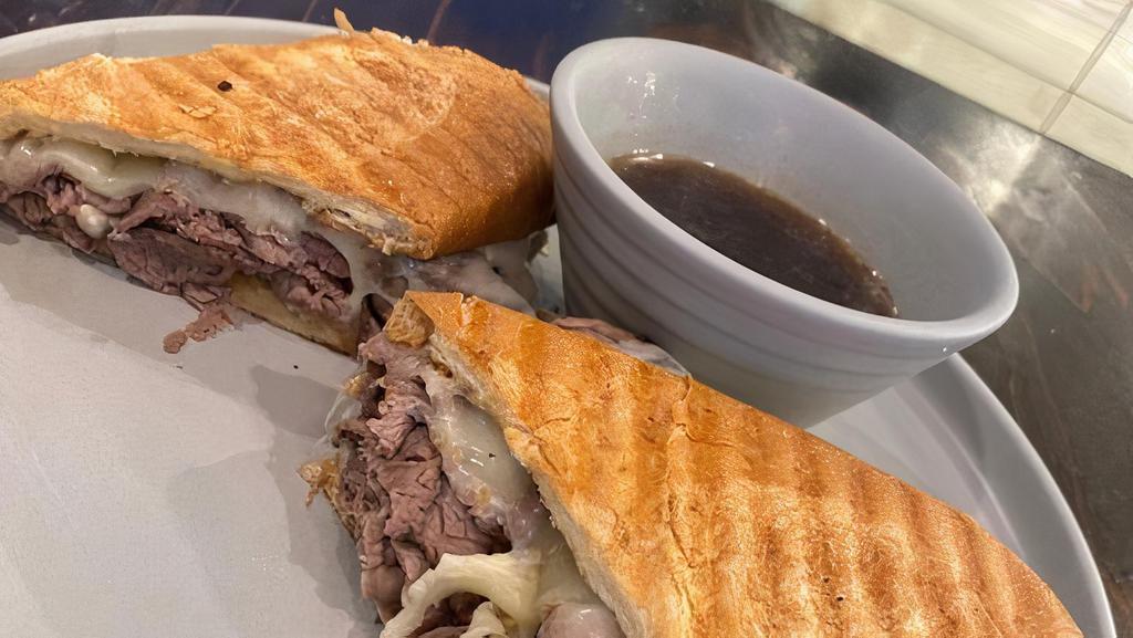 Tri Tip Dip · Thinly sliced grilled tri tip warmed in au jus on a French torpedo roll with horseradish, house mayo, caramelized onions,  and provolone cheese pressed until crisp and served with a side of au jus.