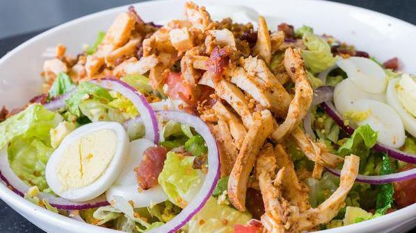 Chopped Salad · Organic romaine lettuce, free range chicken, bacon crumble, boiled eggs, diced tomatoes, red onions, and spicy quinoa with our Dijon vinaigrette dressing.