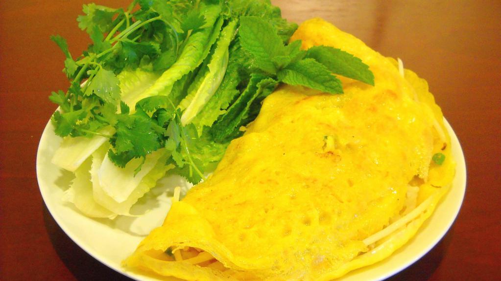 Vietnamese Crepe / Bánh Xèo · Crispy eggless crêpe infused with a hint of turmeric, filled with shrimp, pork, onions, and bean sprouts, accompanied by a bed of romaine lettuce wrappers, fresh Asian basil. Served with nuoc mam.