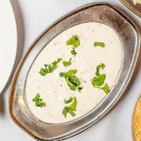 Raita · Homemade yogurt mixed with cucumber, mint, carrot and spices.
