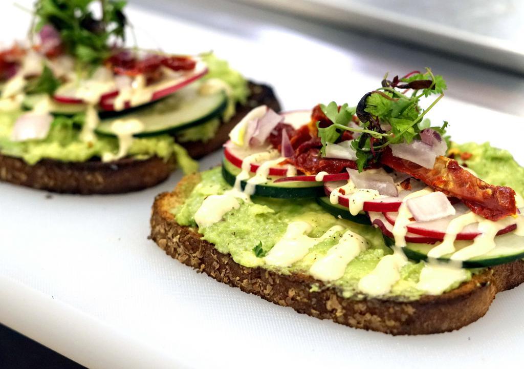 Avocado Toast (or Bagel) · The classic millennial treat!  Smashed avocado on toast or bagel, add sun dried tomatoes, red onions, micro greens, cucumber and red pepper flakes!