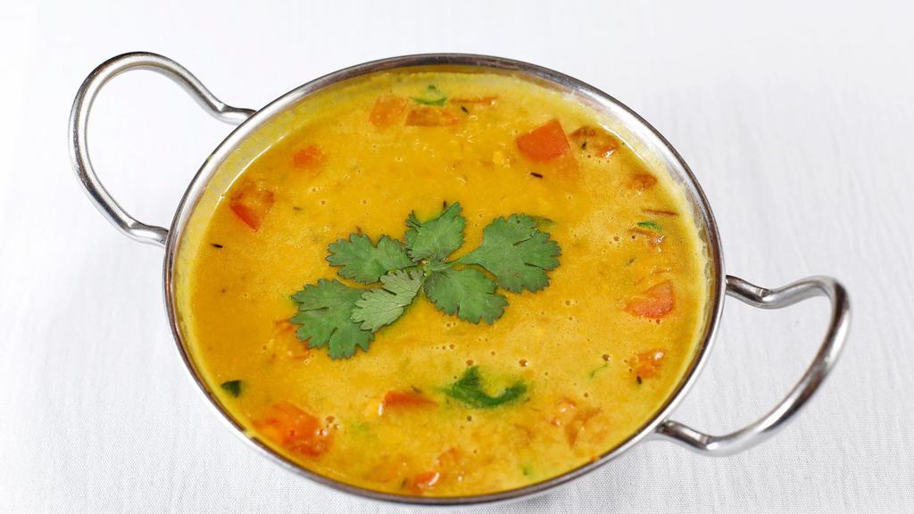 Dal Tadka · Vegan. Split yellow lentil seasoned with tomatoes and garlic, and flavored with a spiced oil called tadka.