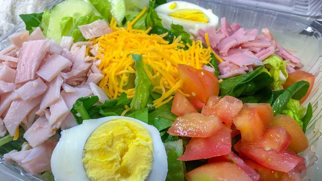 Chef Salad · Bed of romaine, spinach, tomatoes, cucumbers, Ham, Turkey, Cheddar cheese & hard boiled egg.