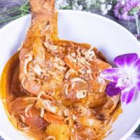 Massaman Curry · Whole chicken leg with peanuts, potatoes, shallots carrots, yellow onions and tamarind in co...